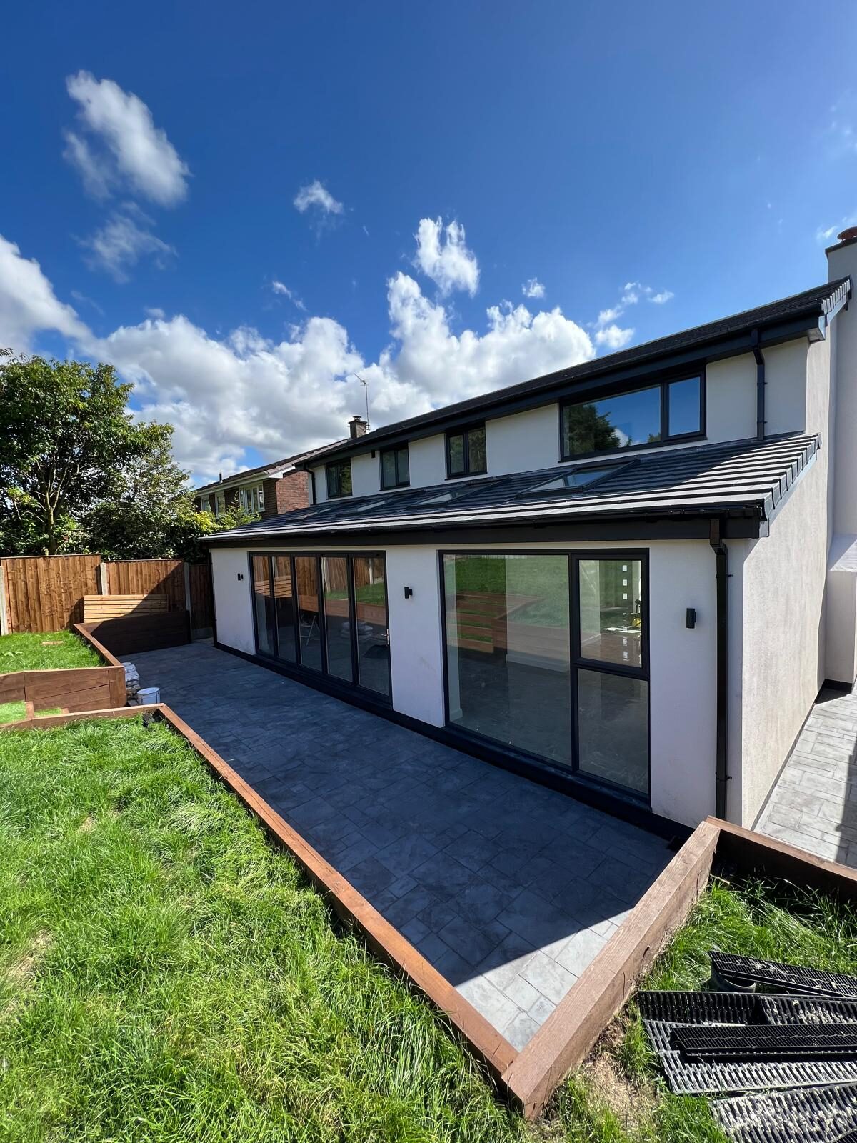 Large anthracite aluminium sliding patio doors along a rear extension