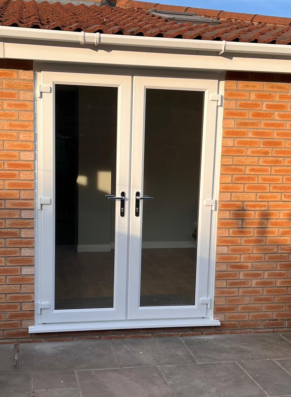 White uPVC French doors installed in a brick bungalow