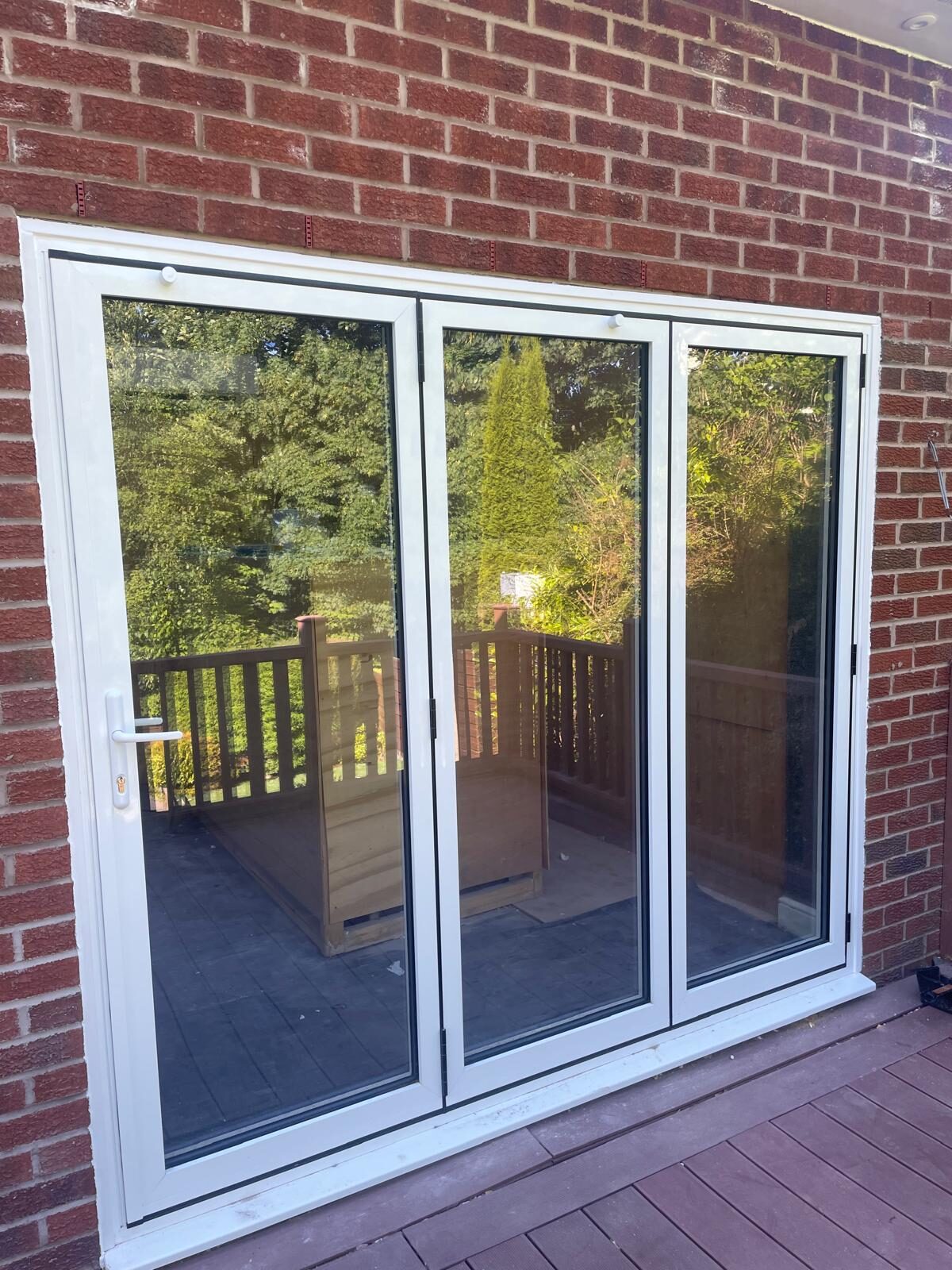 White uPVC three-panel bi-folding doors fitted to a rear elevation
