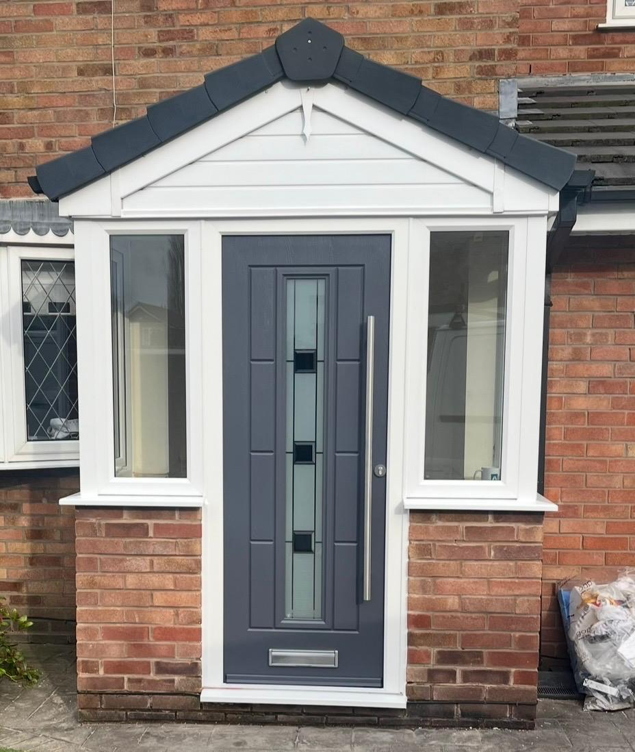 White uPVC porch with a grey composite front door and glazed side panels