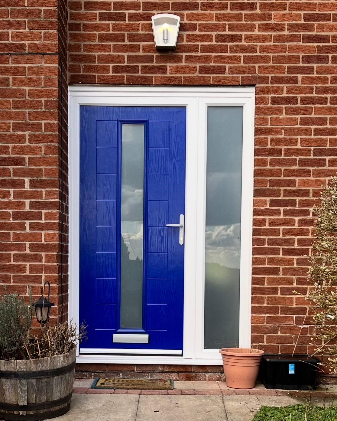Bright blue composite front door with obscure glazed side panel on a brick house