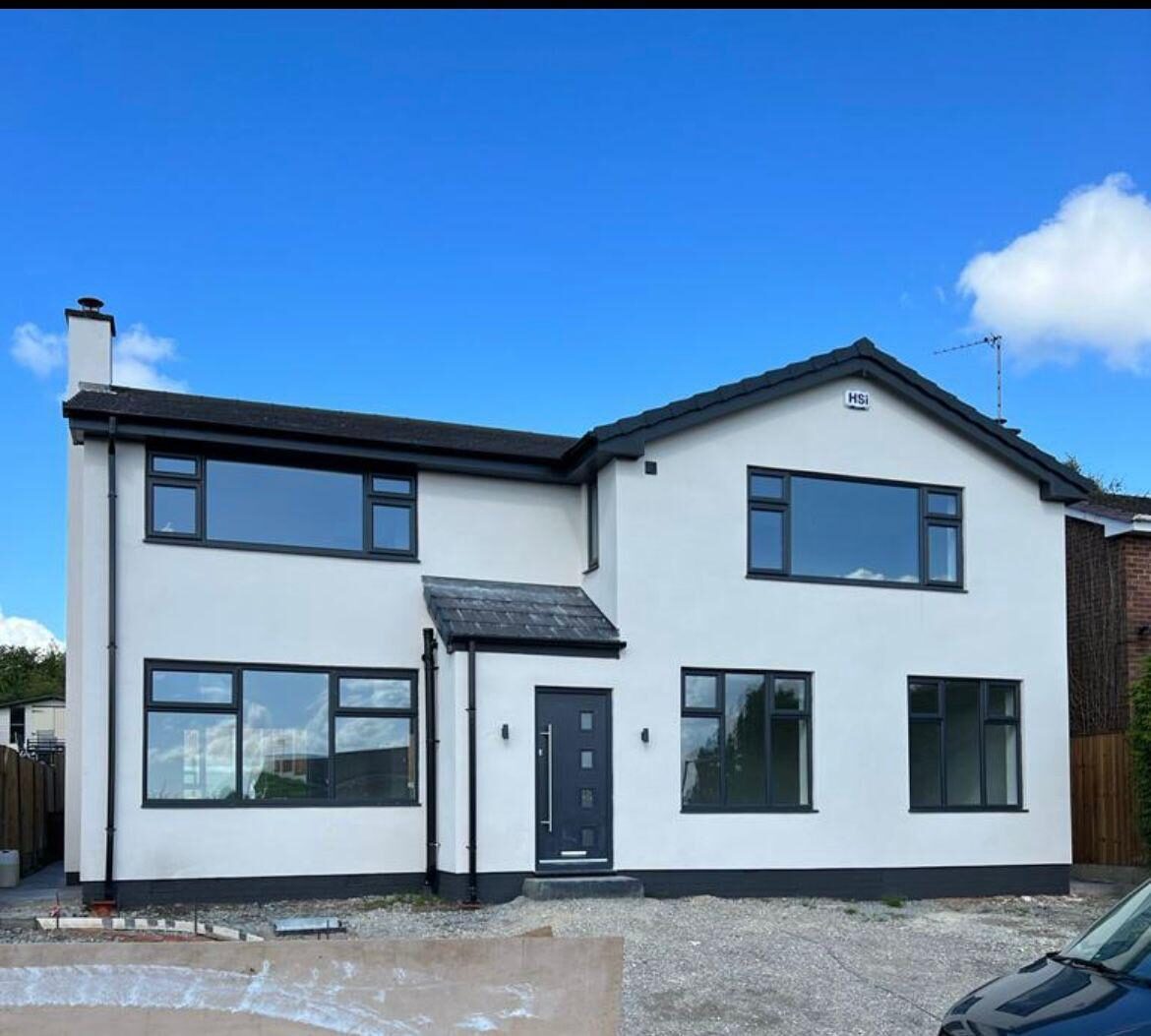 Rendered detached house with anthracite grey windows and a composite front door