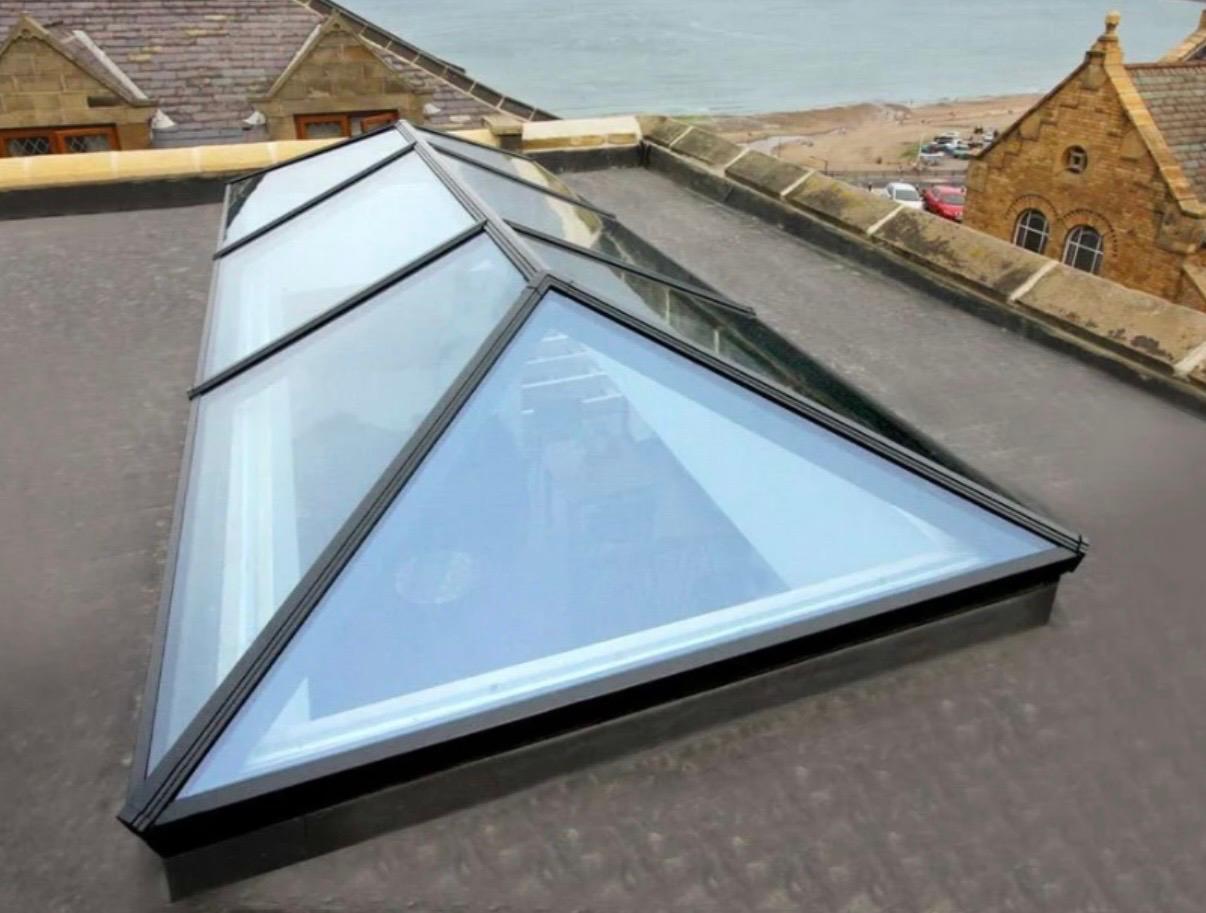 Anthracite aluminium roof lantern installed on a flat roof overlooking the coast